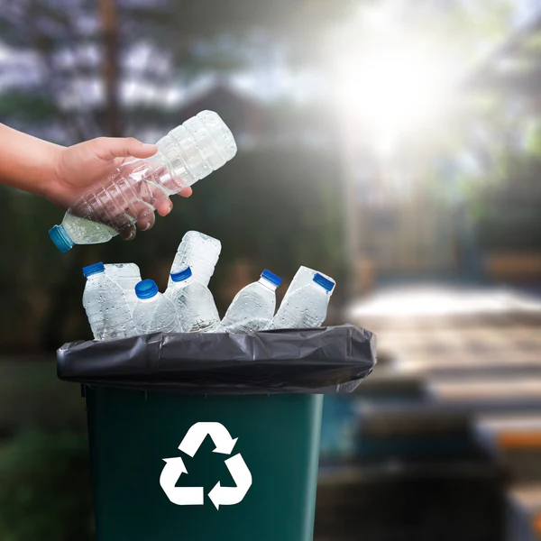 Plastic bottles being placed into a recycling bin